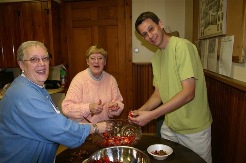 Crunch time, we need more strawberries... fast! Carolyn Celli, Jan Wiley and Bob Gra bowsky jump in to slice more berries